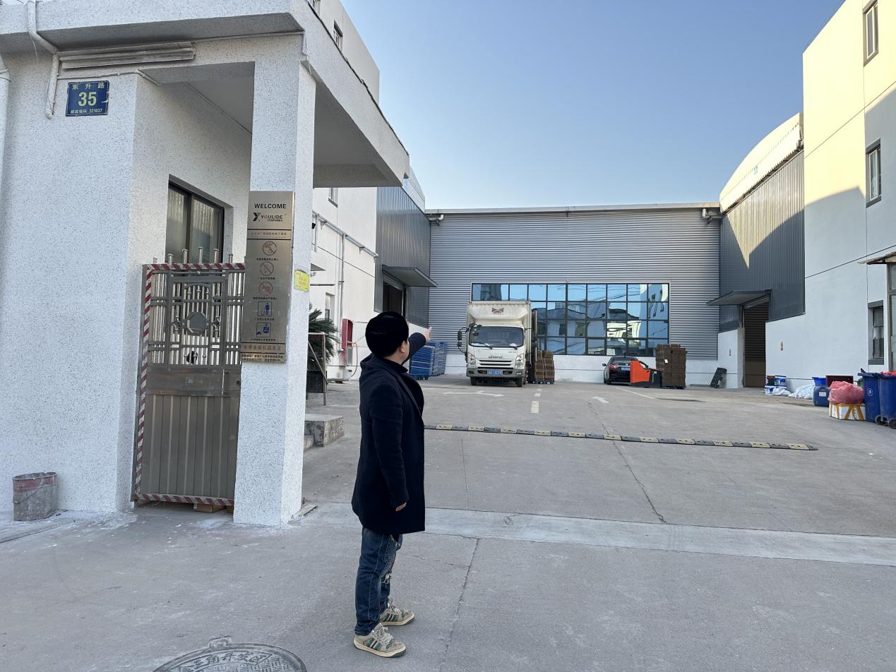 　图为有利德公司负责人指着被拍卖后厂房告诉记者企业已经倒闭。　　　