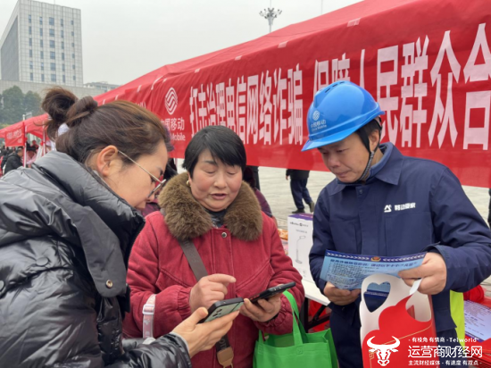 (湖北移動工作人員給市民講解防範電信網絡詐騙知識)