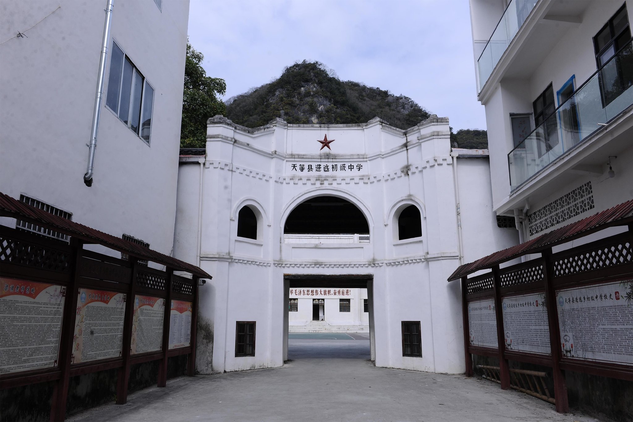 图:中国人寿捐资修缮的进远中学旧校门和教学楼历史革命文物。