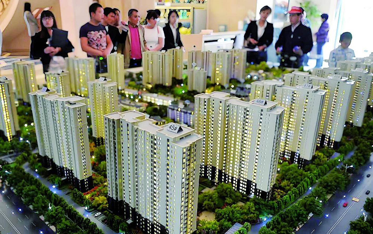 购房者在销售中心查看住宅沙盘