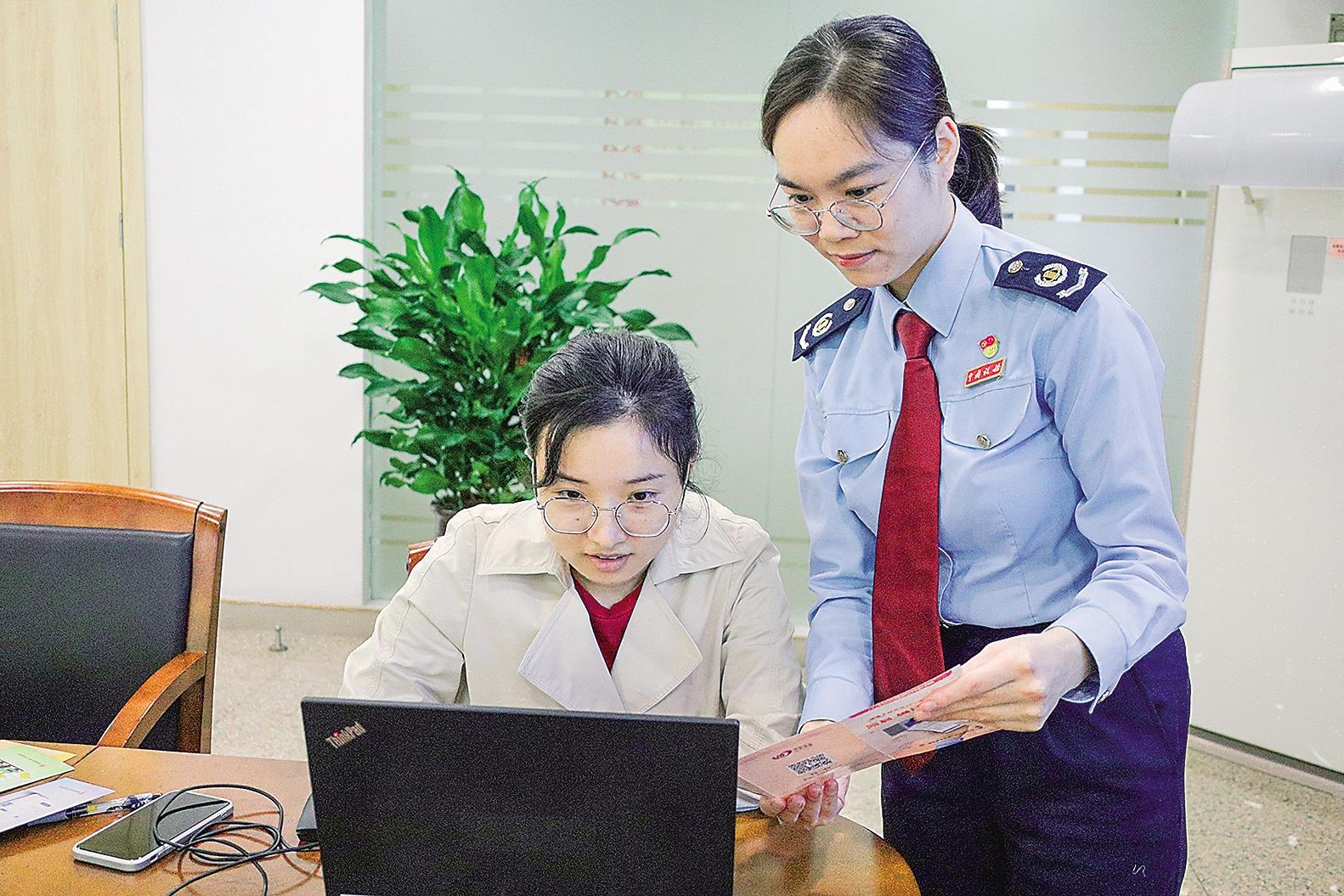 李艳乔（右）为企业提供涉税业务指导。（梁晓林 摄）