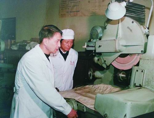 王立鼎（左）与徒弟一起磨削齿轮。