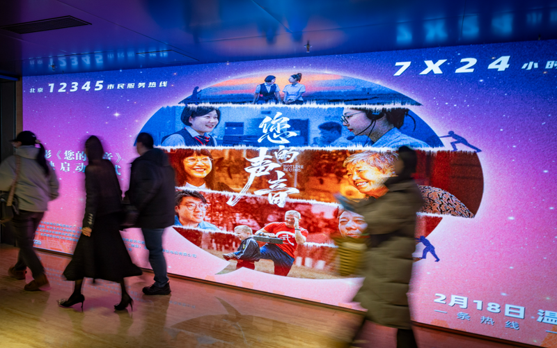 ▲观众走过影片的宣传牌。新京报记者 王远征 摄