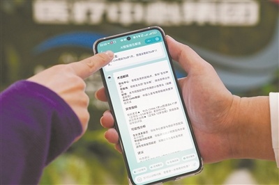 图为护士指导患儿家长使用AI报告解读功能。 崔晓莹摄