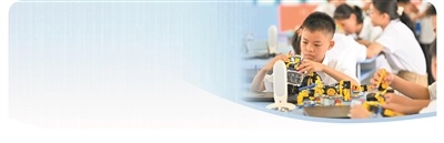 在广西柳州市第八中学南校区人工智能课堂上，学生在科创老师带领下组装智能机器人。 新华社发（黎寒池摄）