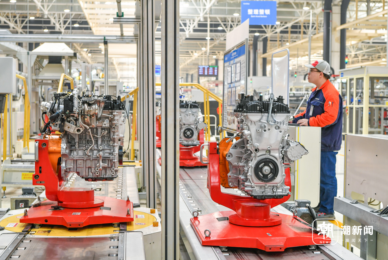 义乌吉利发动机工厂的生产车间内,技术工人在智能化装配流水线上赶制