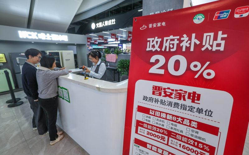 ▲2024年10月31日，顾客在浙江省杭州市富阳区晋安家电的收银台办理政府家电以旧换新补贴的申领手续。图/新华社