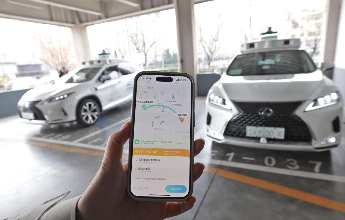 3月13日，乘客在小马智行App上预约自动驾驶接送服务。　新京报记者　王贵彬　摄