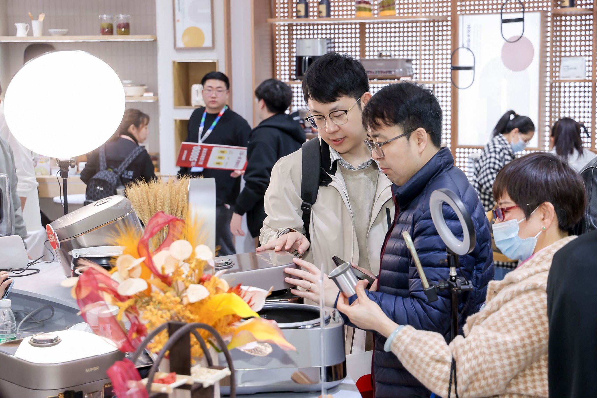 用户在苏泊尔AWE展台观看旋焰釜电饭煲