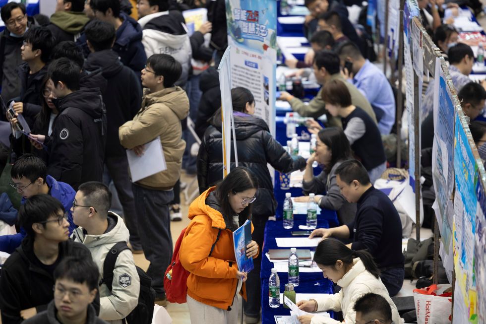 3月26日，在哈尔滨工业大学一校区体育馆内，学生向企业代表咨询就业岗位信息。 新华社记者 张涛 摄