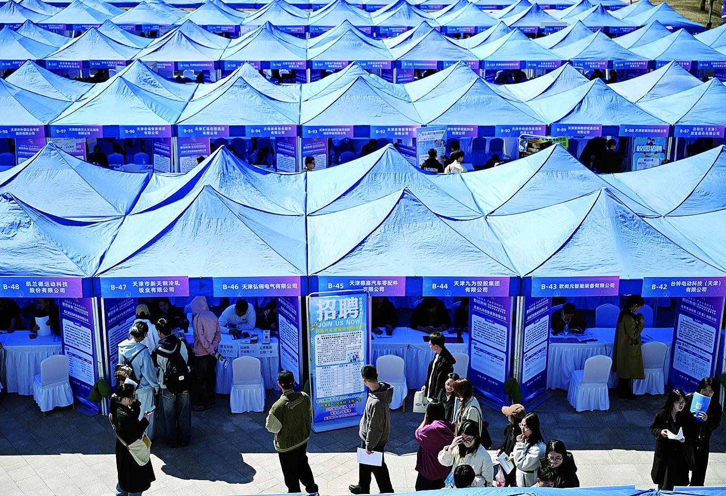 求职学生在招聘会上了解岗位信息 新华社发