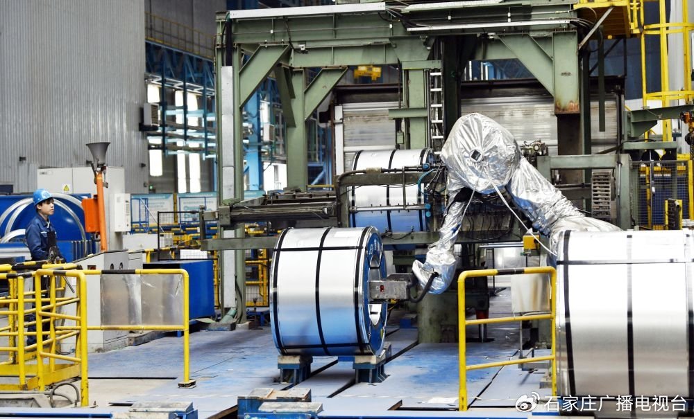 3月26日，首钢迁钢公司热轧作业部酸洗板材作业区，机器人在给钢卷贴标。（梁玉水 摄）