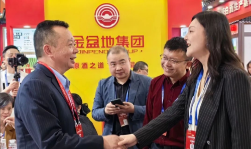 金盆地集团董事长余刚（左）向崇州市副市长康薇（右）汇报参展情况