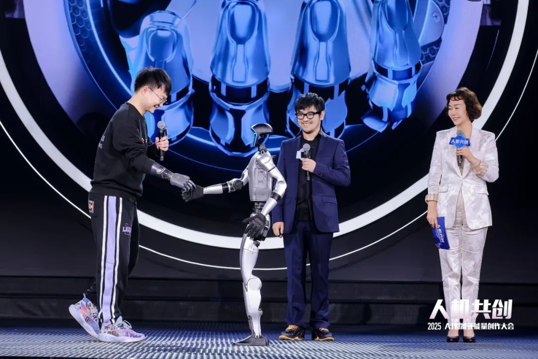 《2025中国·AI盛典》上，机器人与仿生手体验官握手。人民视频供图