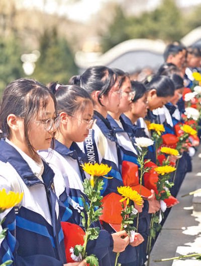 固原二中学生手拿菊花默哀.人民网记者 宽容 摄