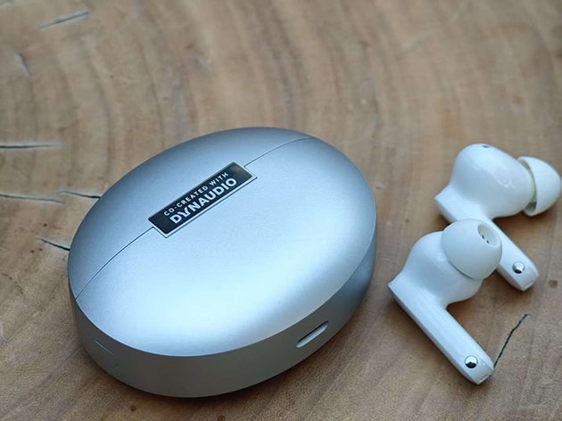 充电盒采用了椭圆饼形设计，表面处理工艺为细腻的哑光金属银涂装，只不过相比旗舰款，充电仓的体积会大一些。