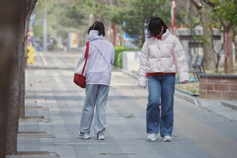 ▲4月12日，北京大兴区天宫院，一阵大风袭来，女士的头发肆意飞舞，小女孩无奈地背风倒走。新京报记者 尹亚飞 摄