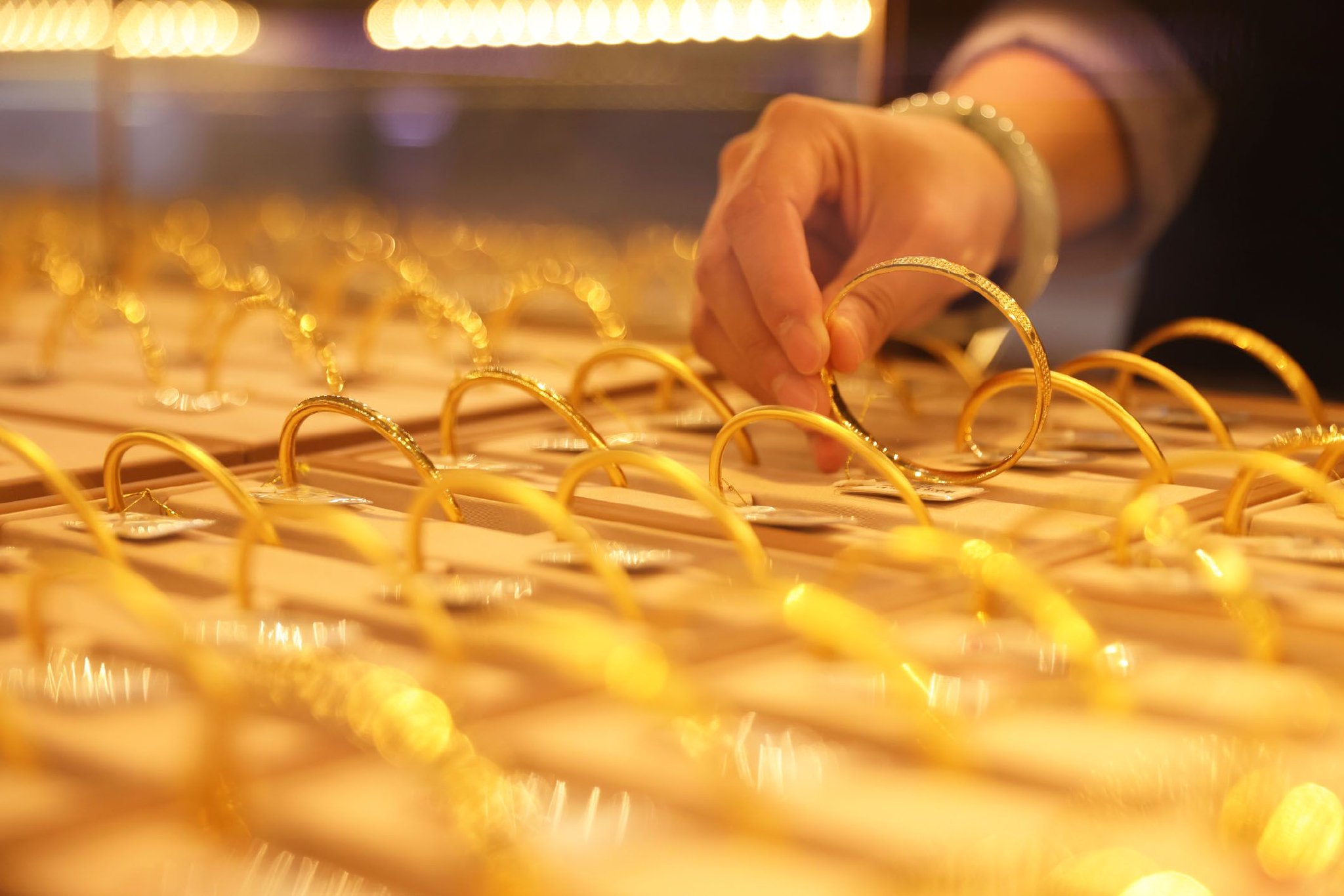 图为浙江省湖州市德清县乾元镇一家金店的营业员在整理黄金首饰。新华社发（倪立芳　摄）