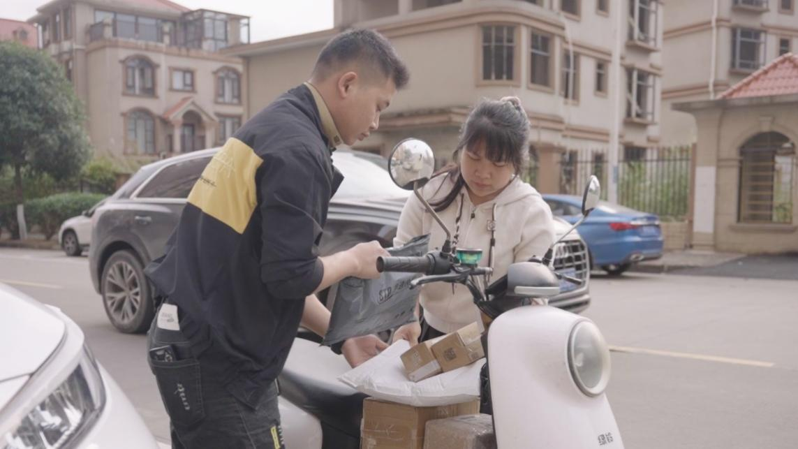 ▲这家驿站由宁西川夫妇共同经营，图为两人整理快递，为街边店铺送货。莫根源 | 摄