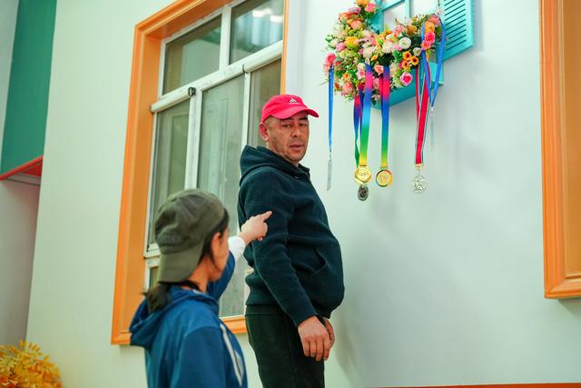 Naifese's father sorting through her medals and documents.