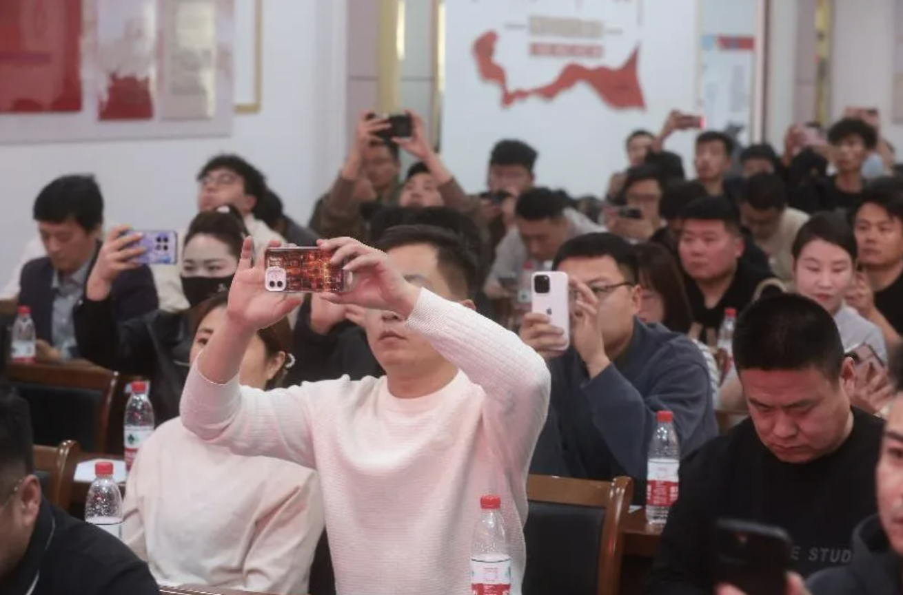 「多多好特产」培训会现场，商家正在拍摄平台扶持新政策｜图片来源：顾炜 摄