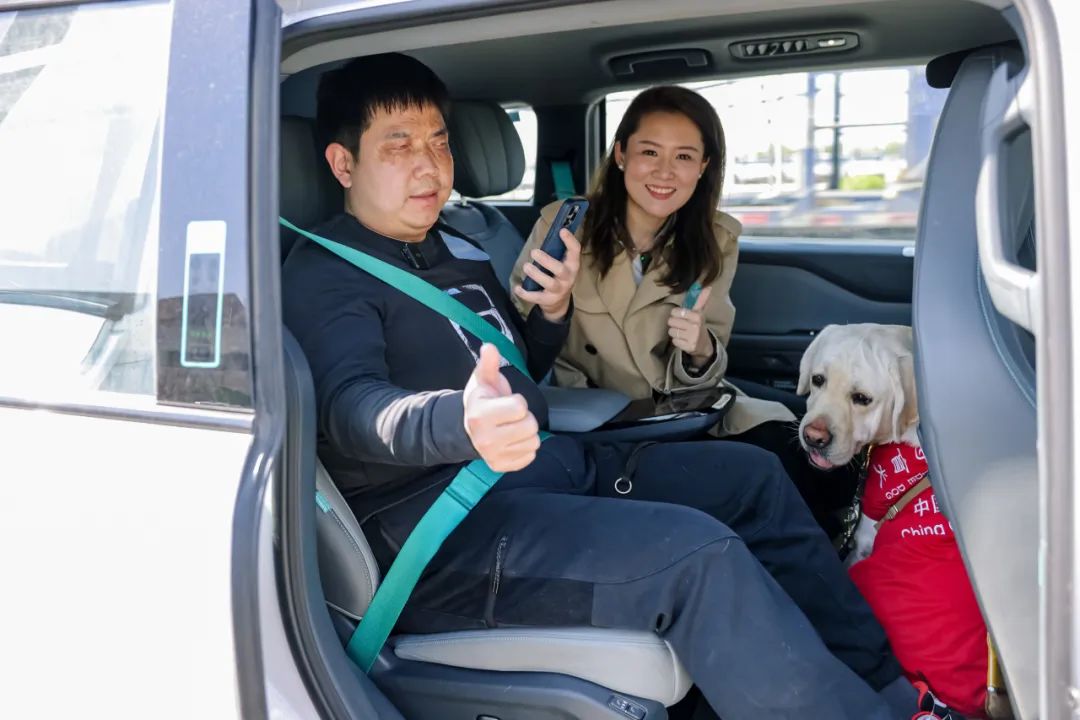 陈金陪着乔玉和“路虎”一同体验萝卜快跑“无障碍关爱功能”