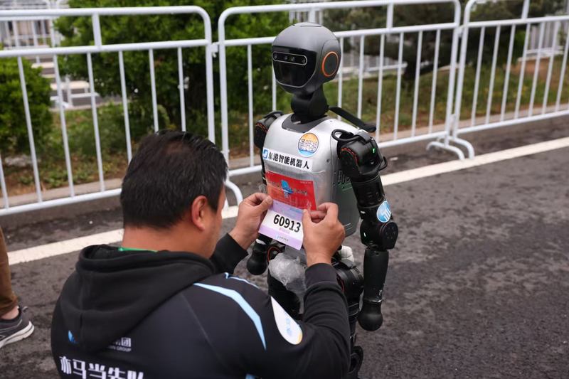 责任主谈主员给参赛东谈主形机器东谈主贴标签。新京报记者 李木易 摄