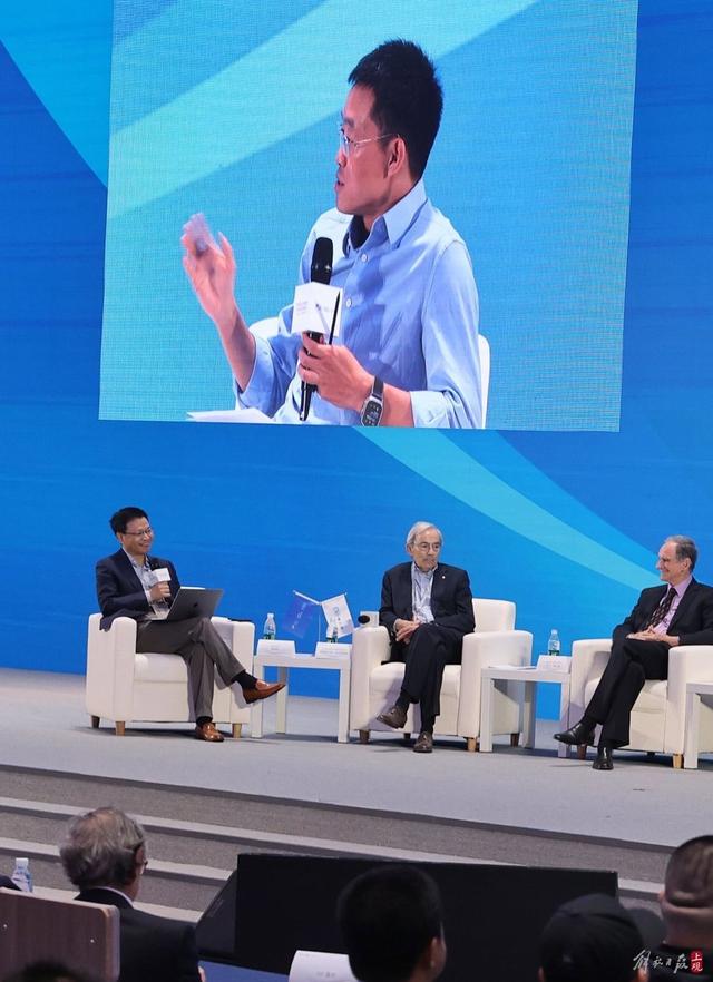 鄂维南（左一）在上海举行的世界顶尖科学家论坛上主持。徐瑞哲 摄