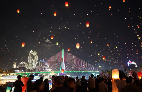 图1：2025年4月13日，云南西双版纳，民众在景洪市澜沧江边放飞孔明灯，庆祝泼水节。梁志强/摄   
