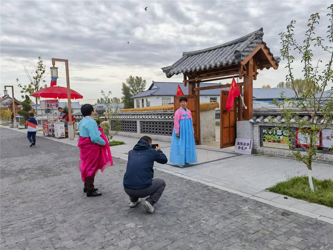 　　游客身着民族服饰感受乡村惬意生活。（资料图）