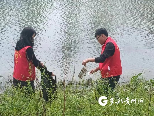蒋泽南(右)清理河边垃圾