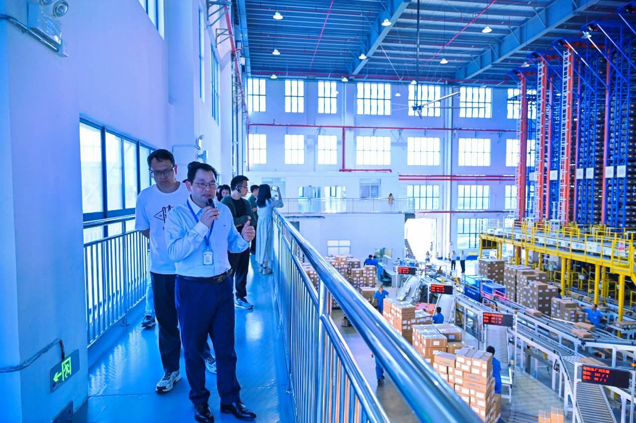 图：浔兴拉链总经理何国平介绍智能仓储中心