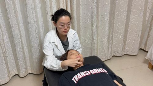 魏译辰（左一）用“能量手”为患者调整