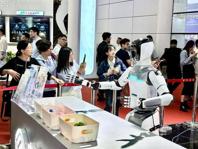 第八届数字中国建设峰会现场，游客驻足围观人形机器人。（郑雅梅 摄）
