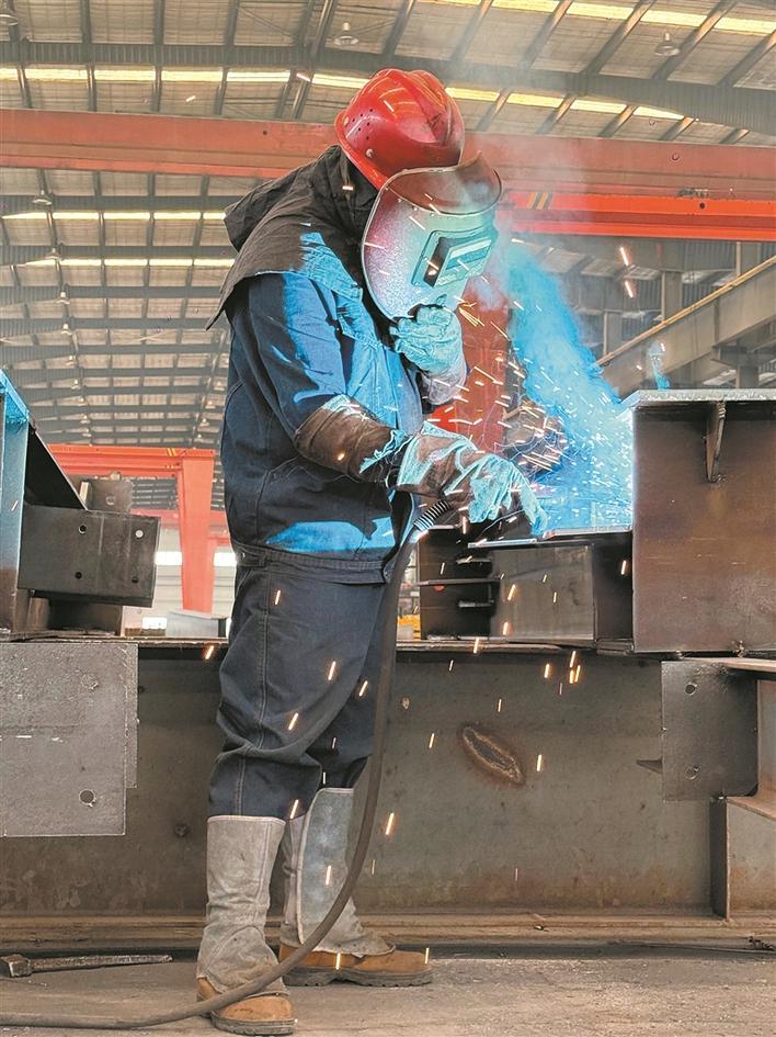 新疆三合万宏钢构环保科技有限责任公司工人在焊接钢板