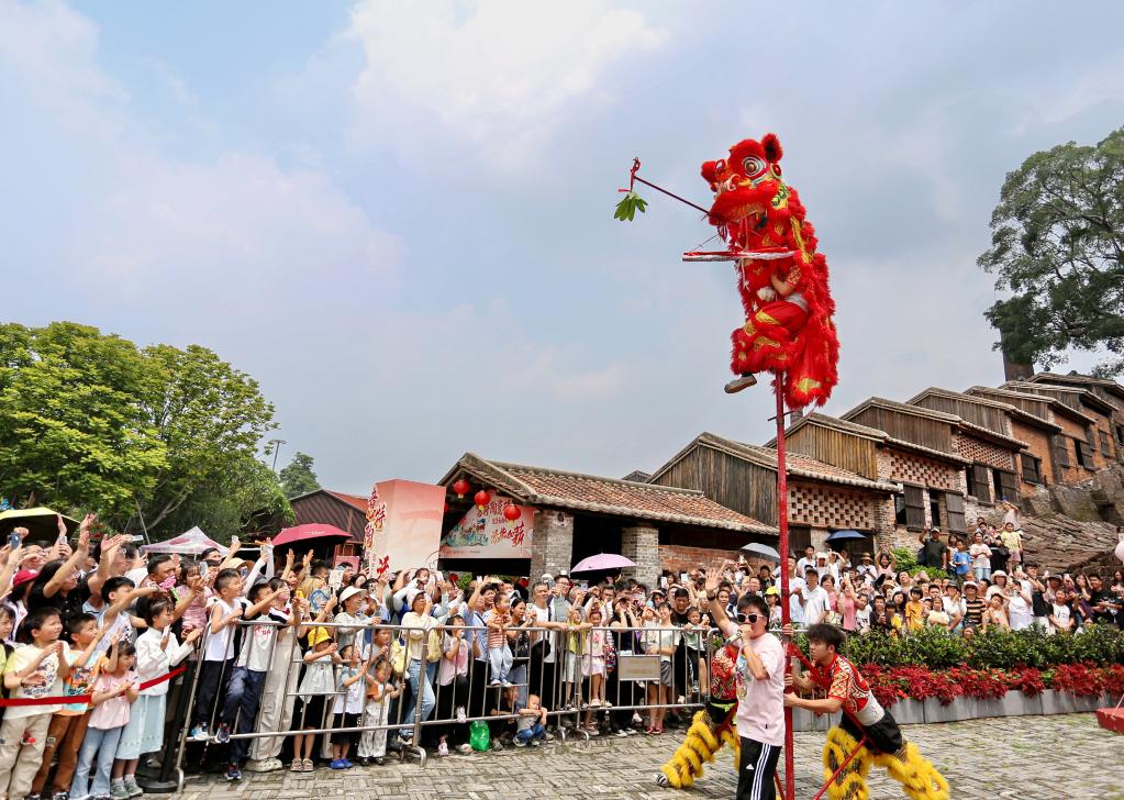 　　5月2日，在广东省佛山市禅城区南风古灶旅游休闲街区，游客在观看醒狮表演。新华社发（黄继明 摄）