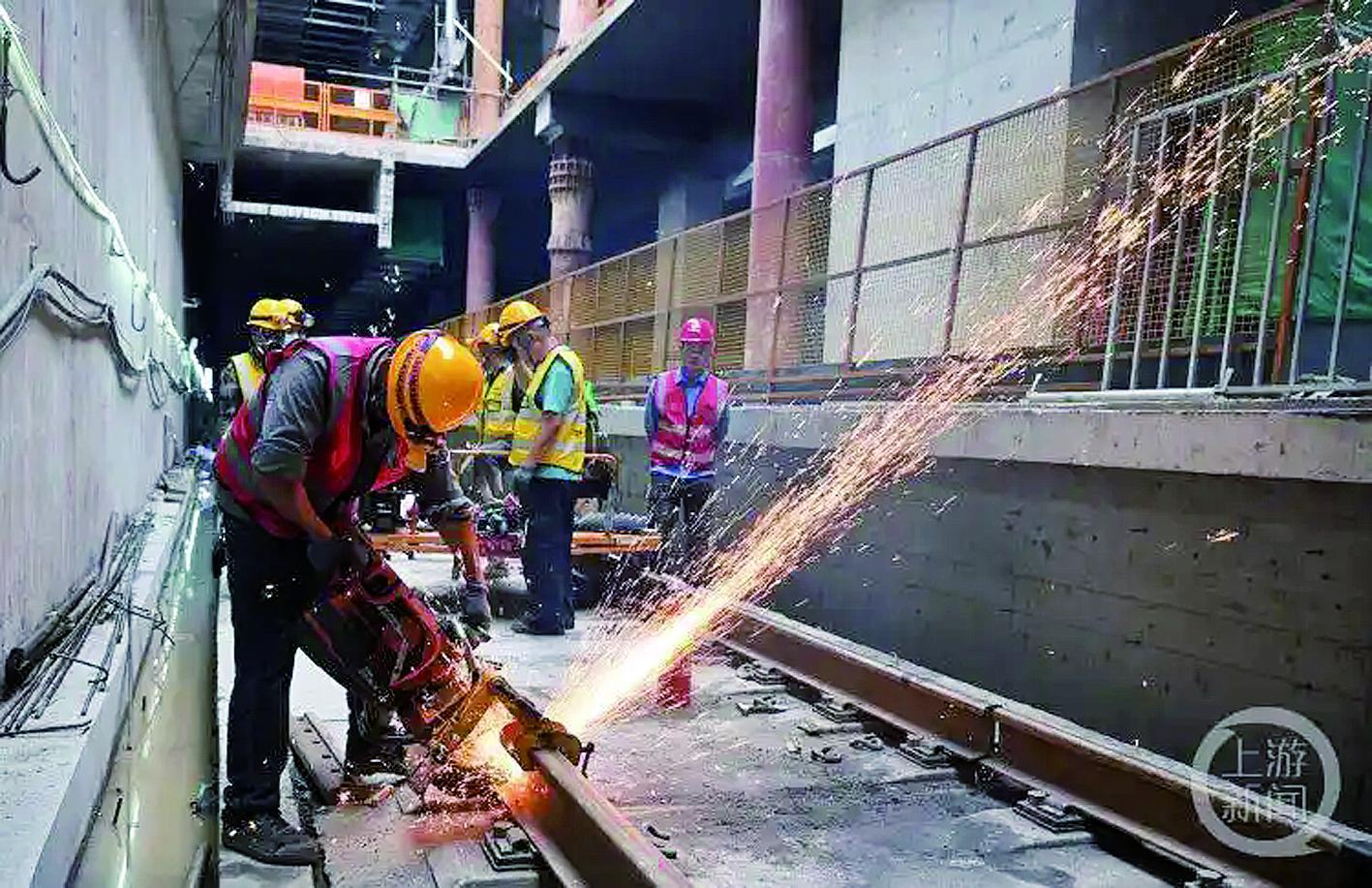 施工现场,工人对钢轨头进行无缝焊接。