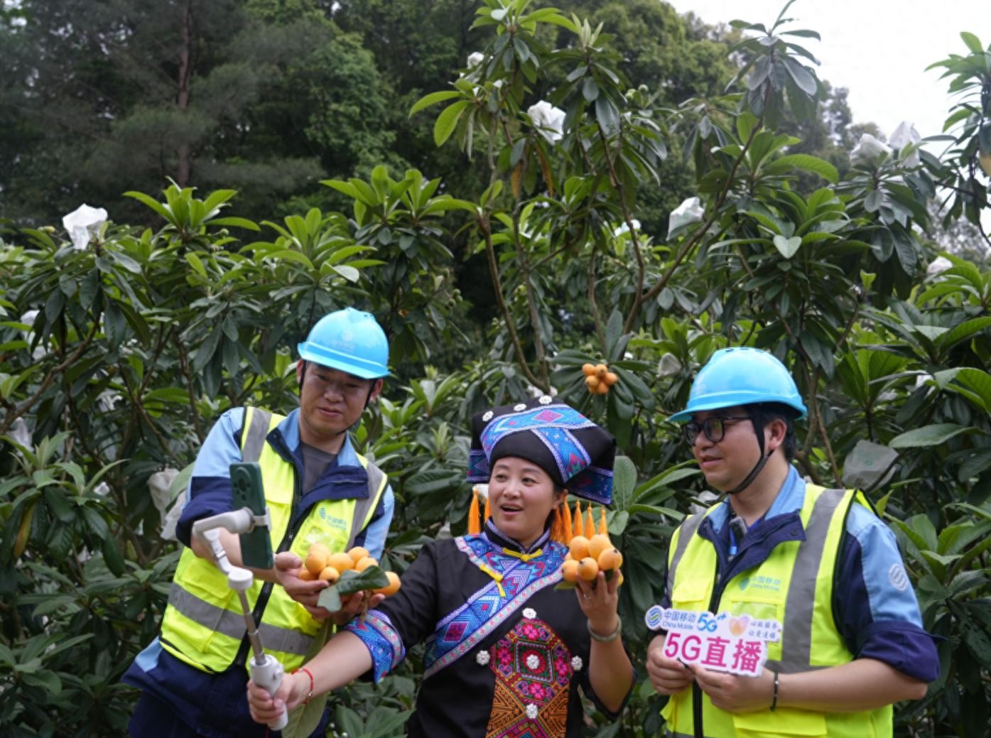 图为中国移动网络人员帮助果农开展5G直播。