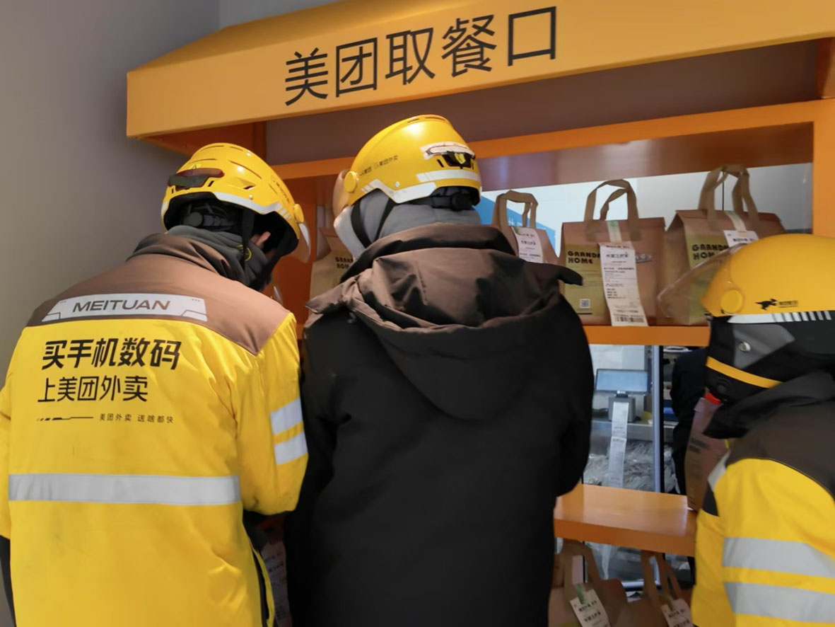 图为骑手在外卖取餐口取餐。张培松 摄