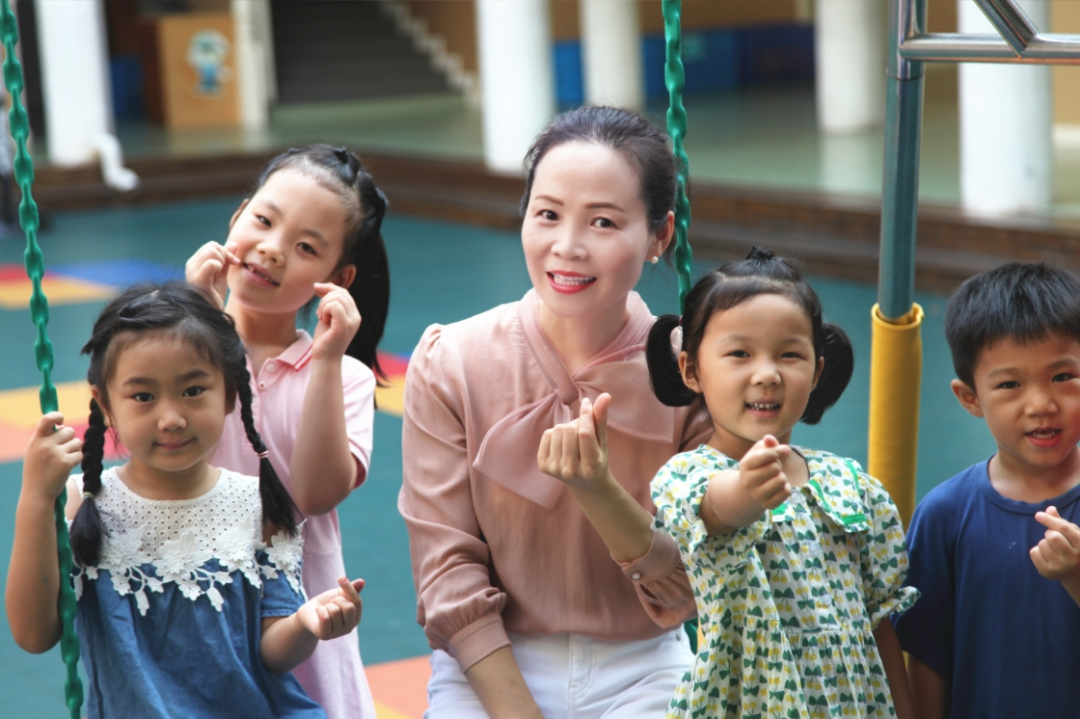徐丽娟与幼儿园的孩子们在一起。资料图片