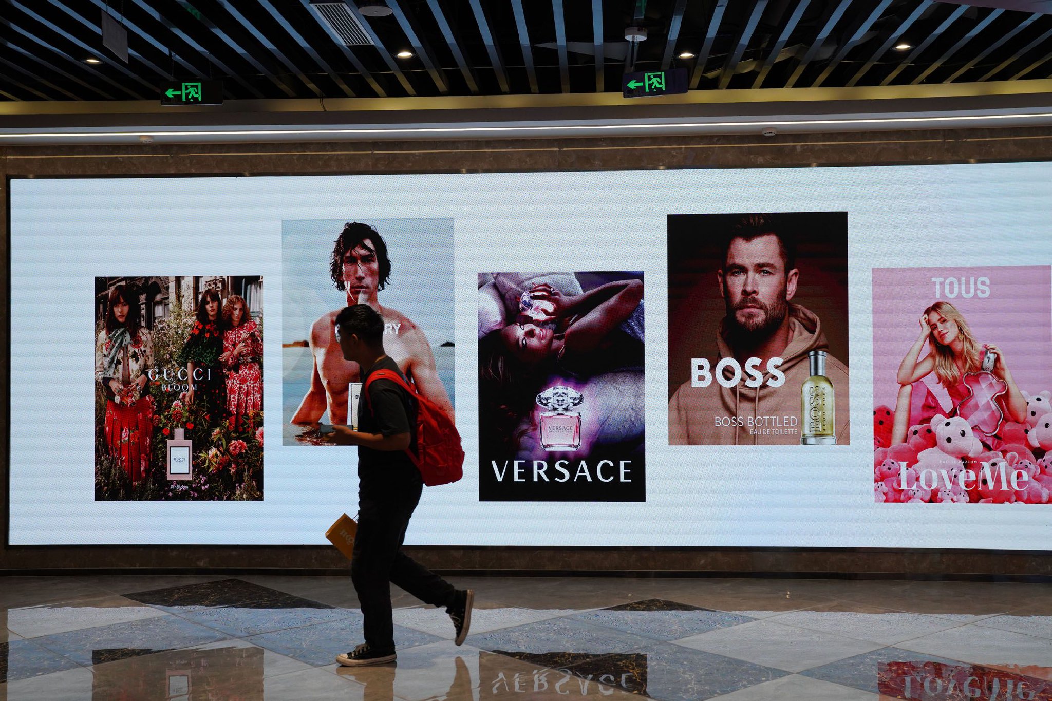 一位行人从广告牌前走过。（资料照片）