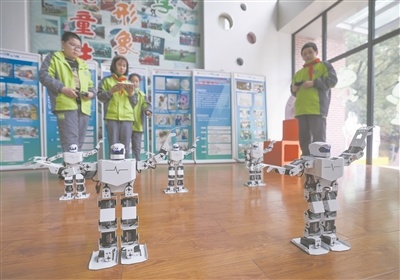 在嘉兴市实验小学科技城校区科创中心内，学生们在对智能机器人进行动作指令调试。新华社记者 徐昱摄