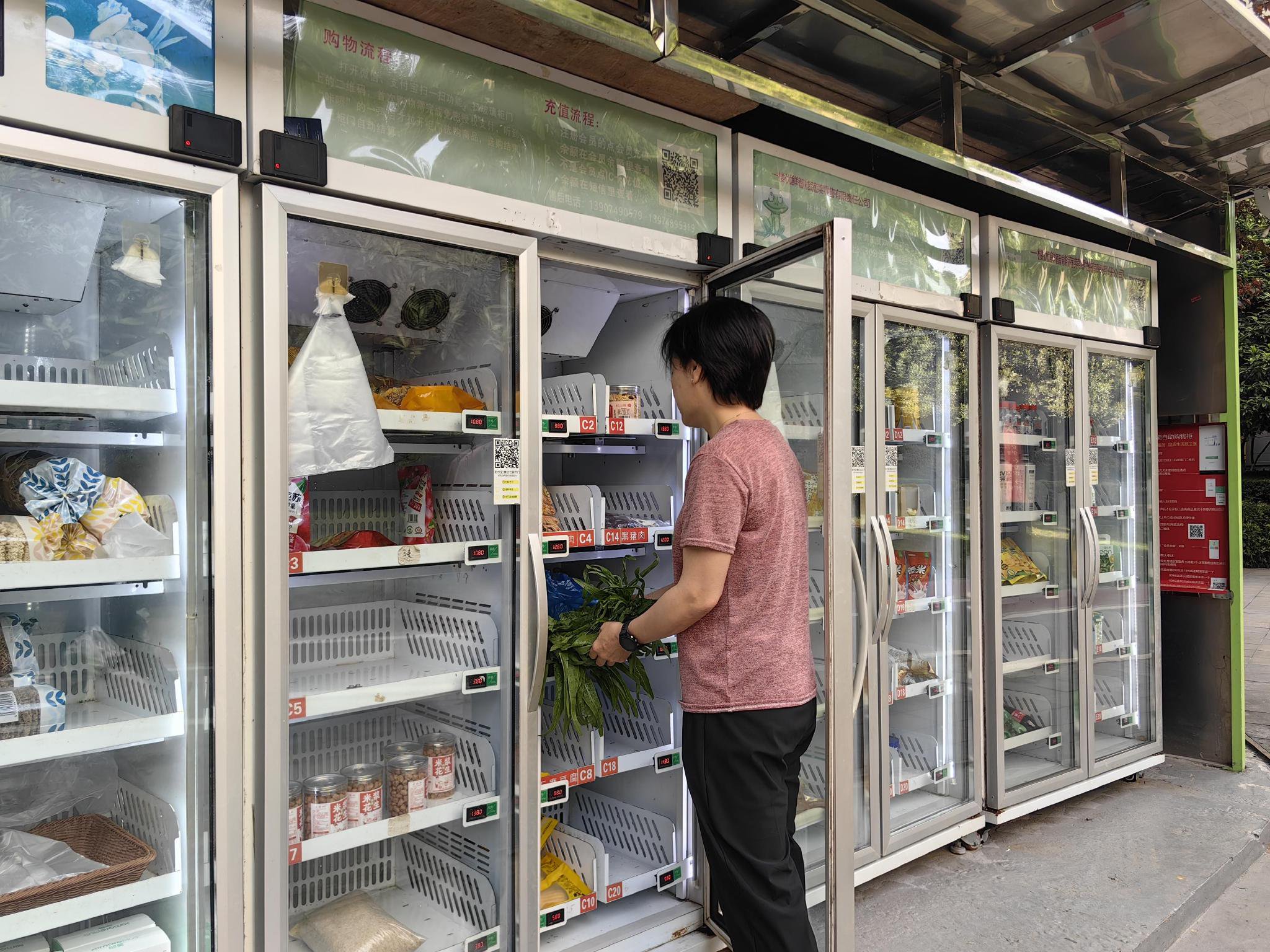 小区居民通过智能自助购物柜购买时令蔬菜。余知都/摄