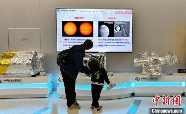 5月17日，长春市民带孩子参观长春光机所先进科技成果。 郭佳 摄