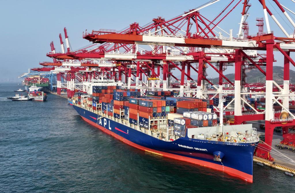 4月30日，货轮在青岛港前湾集装箱码头装卸集装箱（无人机照片）。新华社记者 李紫恒 摄