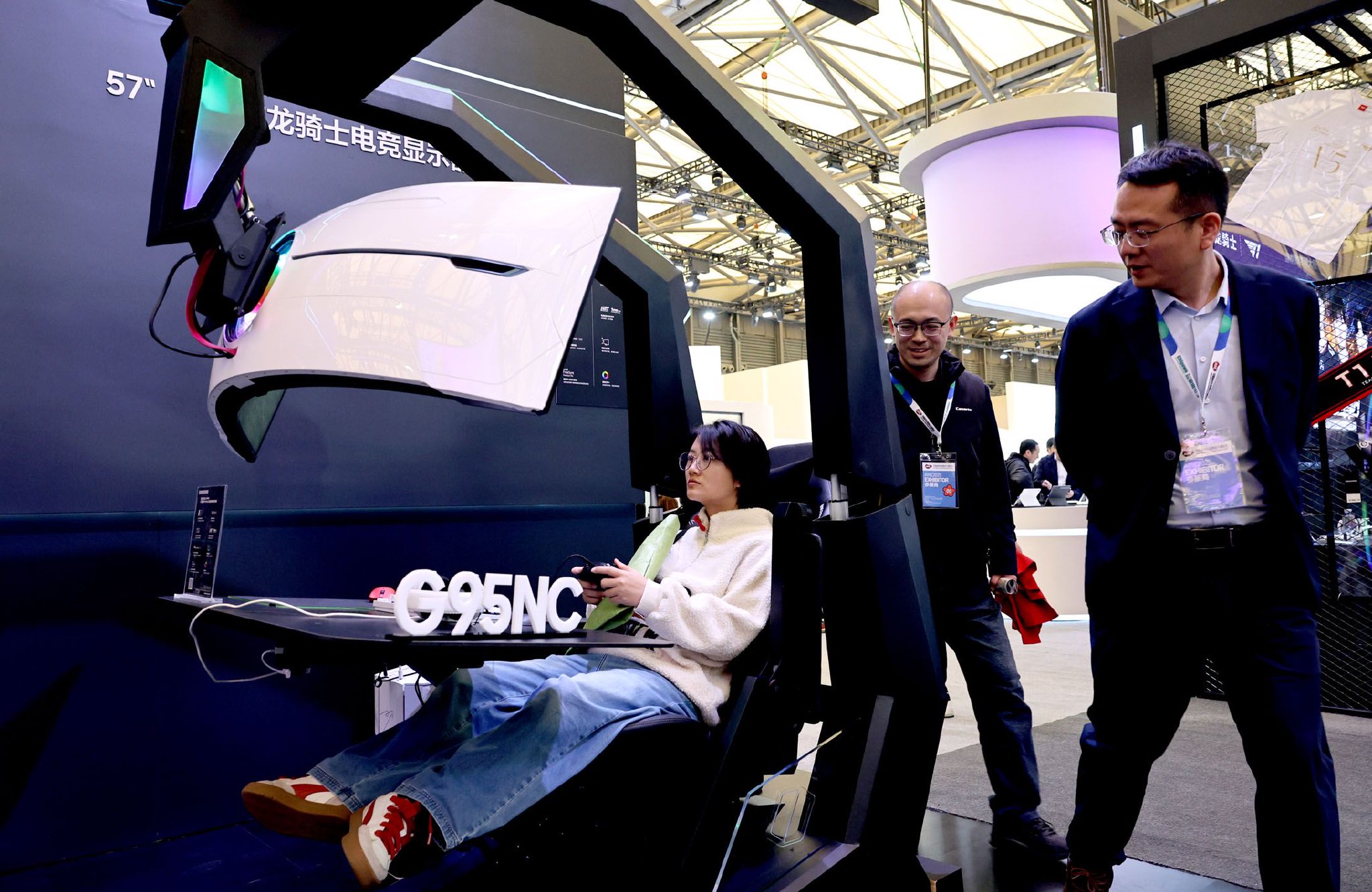 图为参观者（左）在体验一款装备了弧形电竞显示器的游戏座舱。新华社记者　方喆　摄