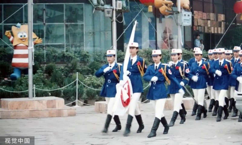 1998年，郑州，二七广场的郑州亚细亚商场礼仪小姐升旗仪式。马健/摄