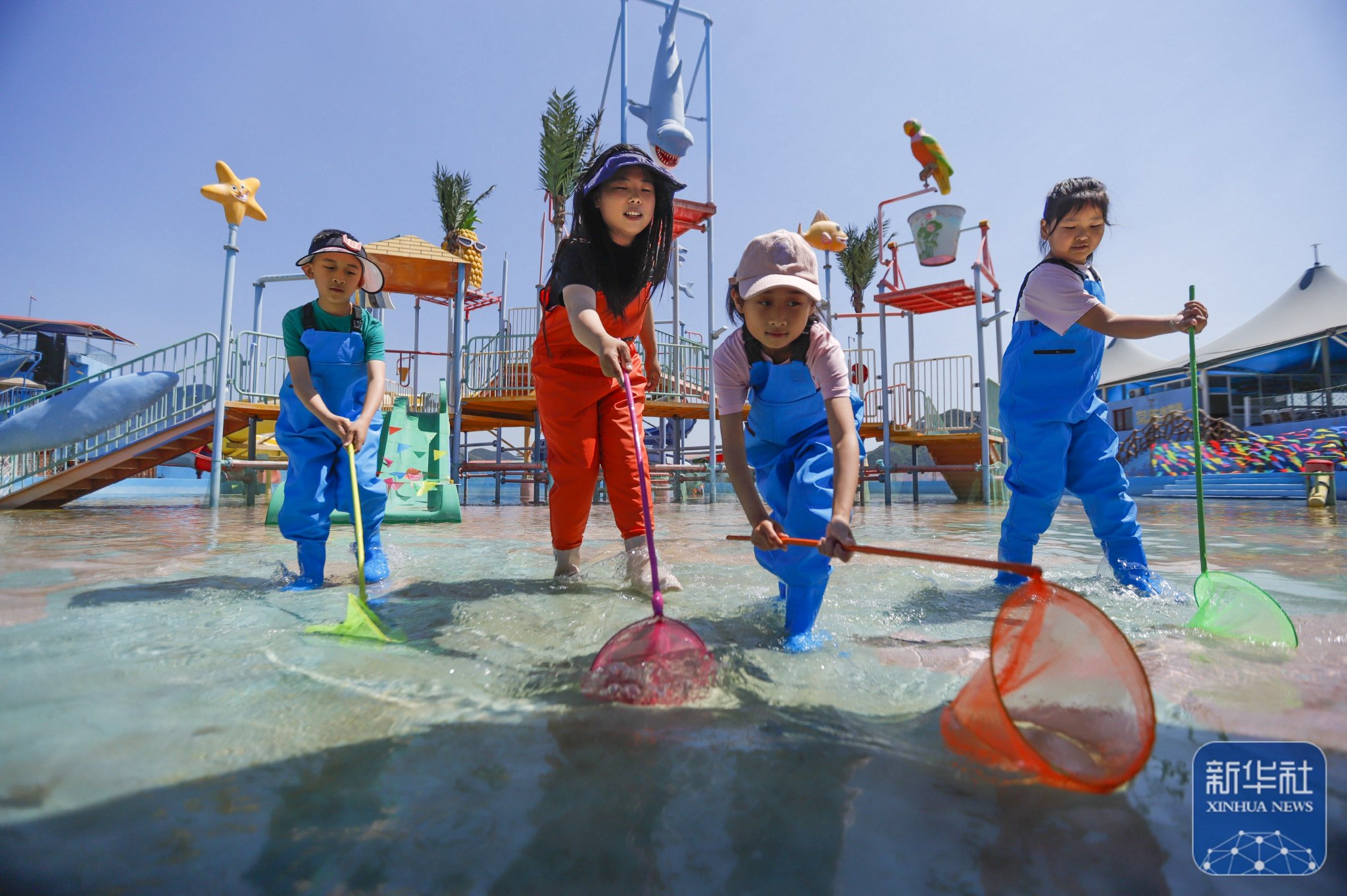 5月24日,游客在河北省遵化市南山常乐谷景区水世界参加亲子捞鱼活动