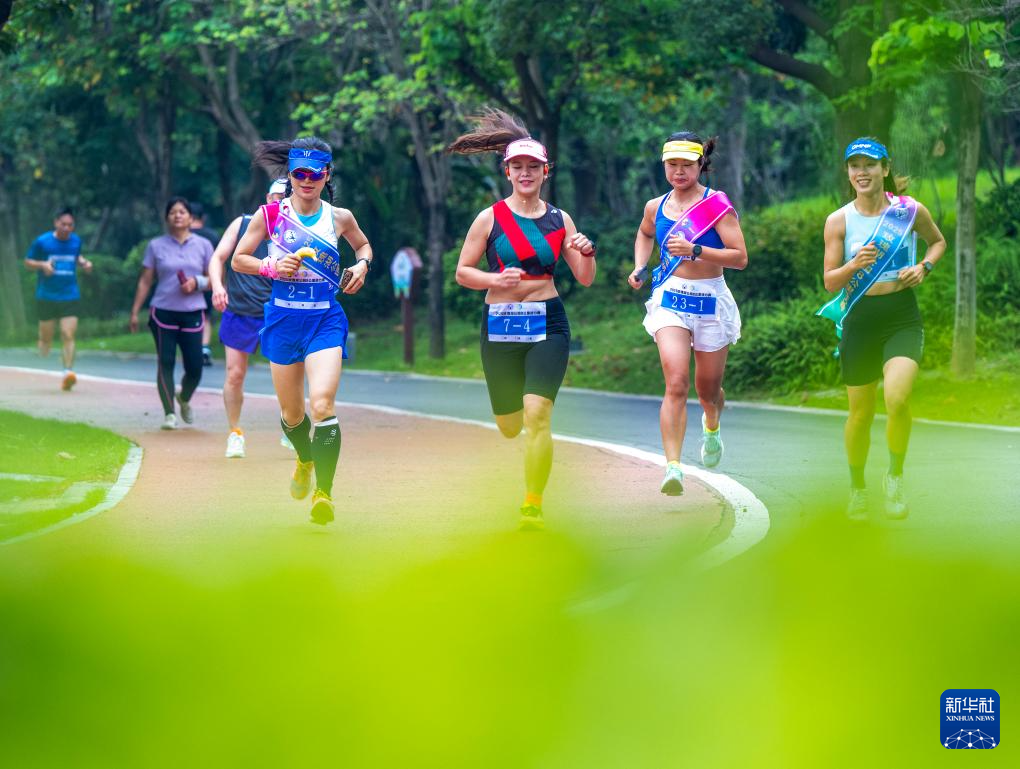 5月25日,跑步爱好者在广西梧州市玫瑰湖公园参加跑步接力赛