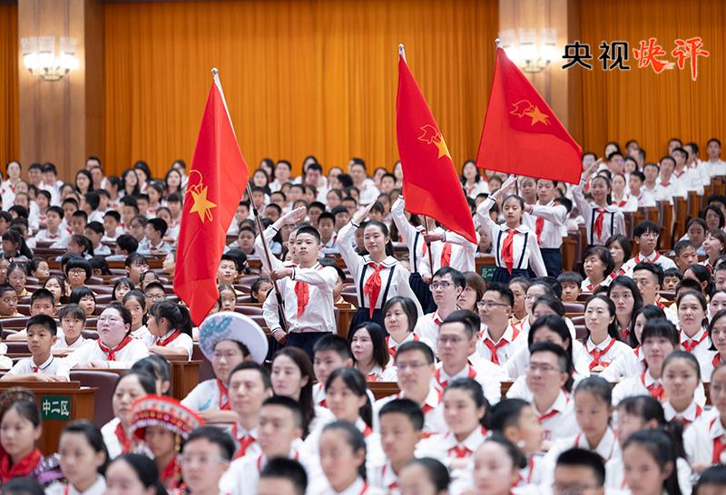 央视快评丨高举队旗跟党走